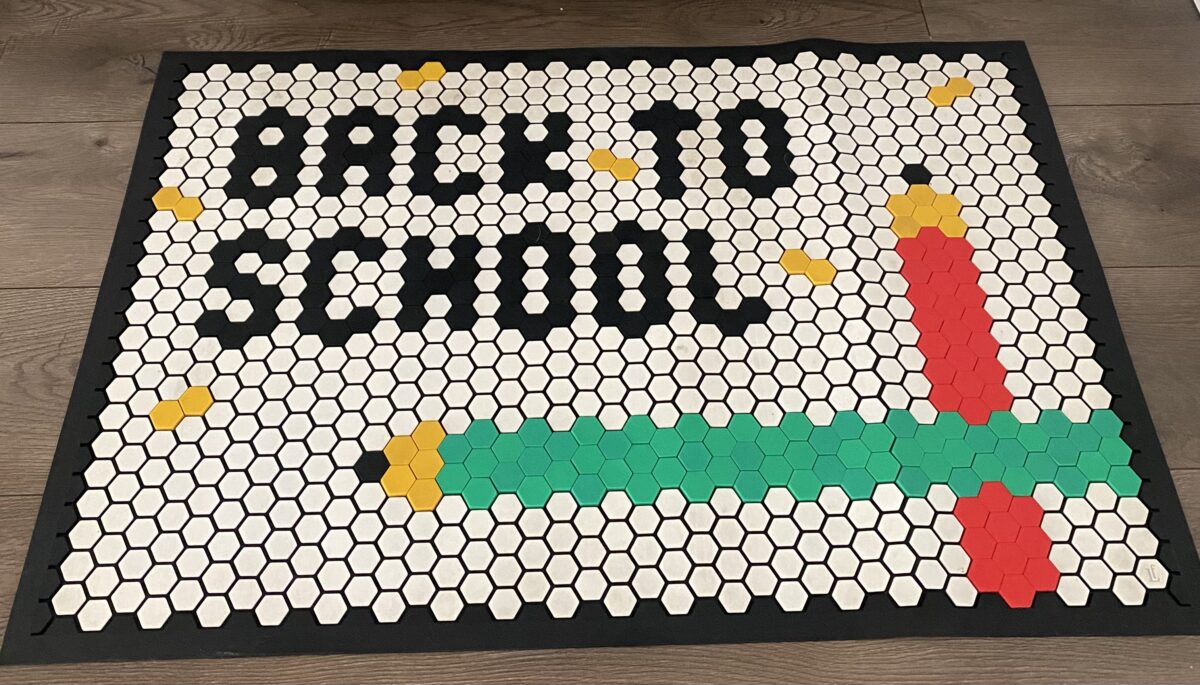 A door mat with the words "Back to School" along with red and green pencils.