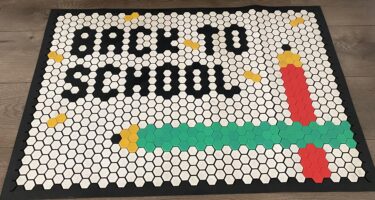 A door mat with the words "Back to School" along with red and green pencils.